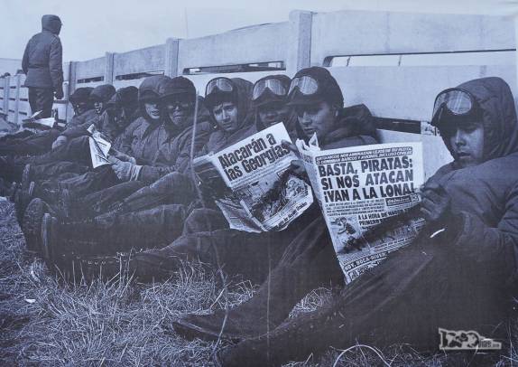 Soldados argentinos leem jornais entrincheirados nas Malvinas no início da guerra (fotografia em exposição em praça de Ushuaia, no sul da Terra do Fogo, na Argentina)